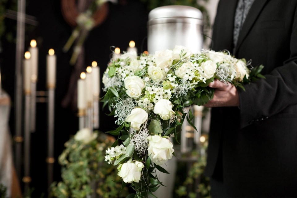 Blommor vid urna och ljus